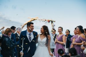 confetti being tossed at couple walking down aisle after getting married