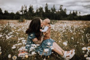 mother holding newborn in a daisy field cowichan valley photographer